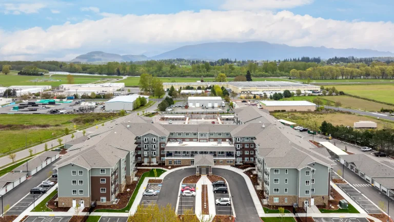 Affinity at Burlington's front entrance and parking from above with mountains in the distance