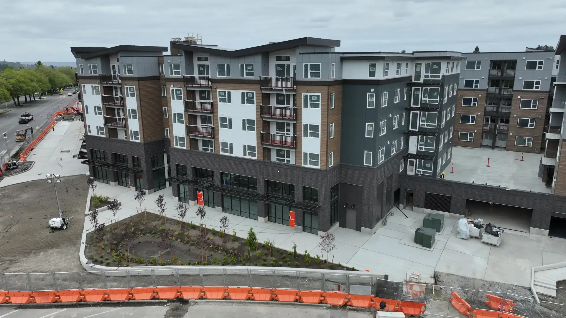 Completed corner of Solera Building A with street-level storefronts below the apartment floors
