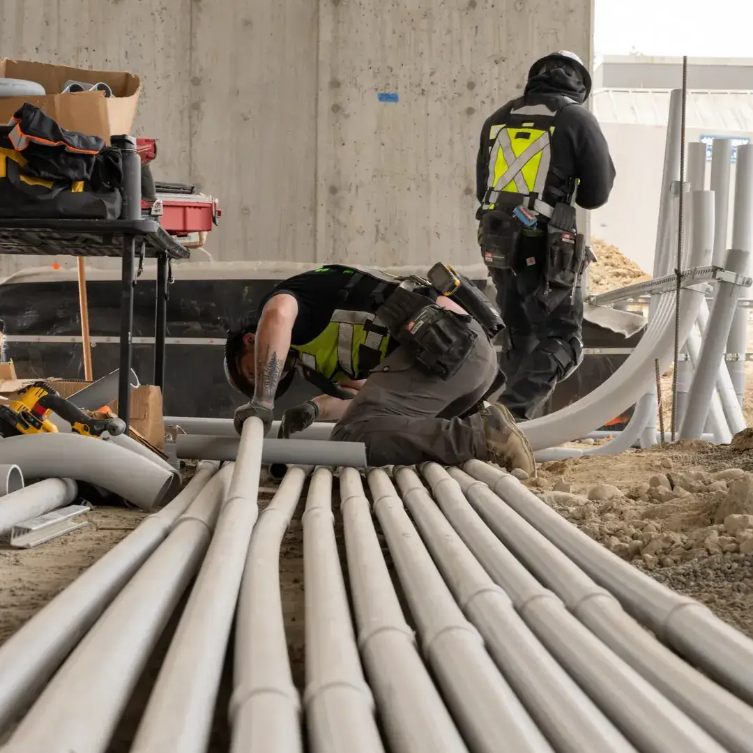 Crew members working over a pile of underground conduit